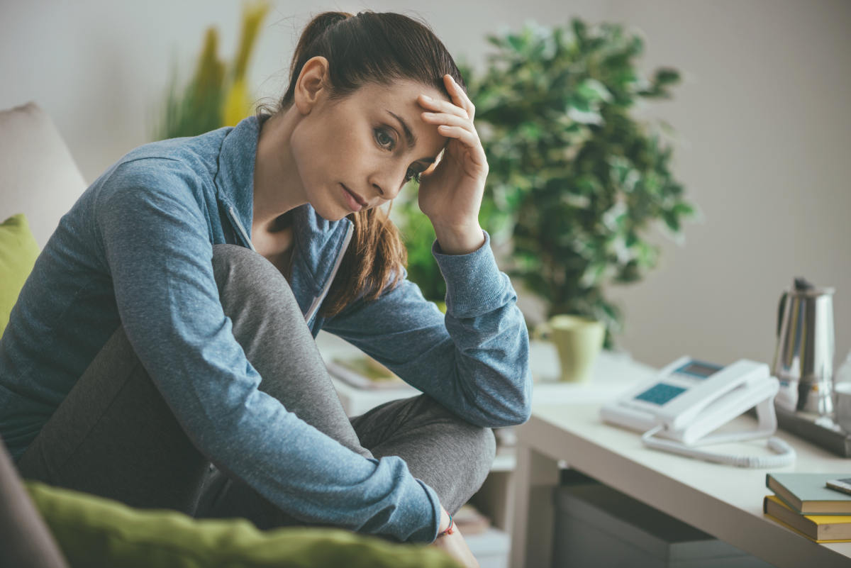 Sad depressed woman at home sitting on the couch | Premenopause | Perimenopause Symptoms and What To Expect