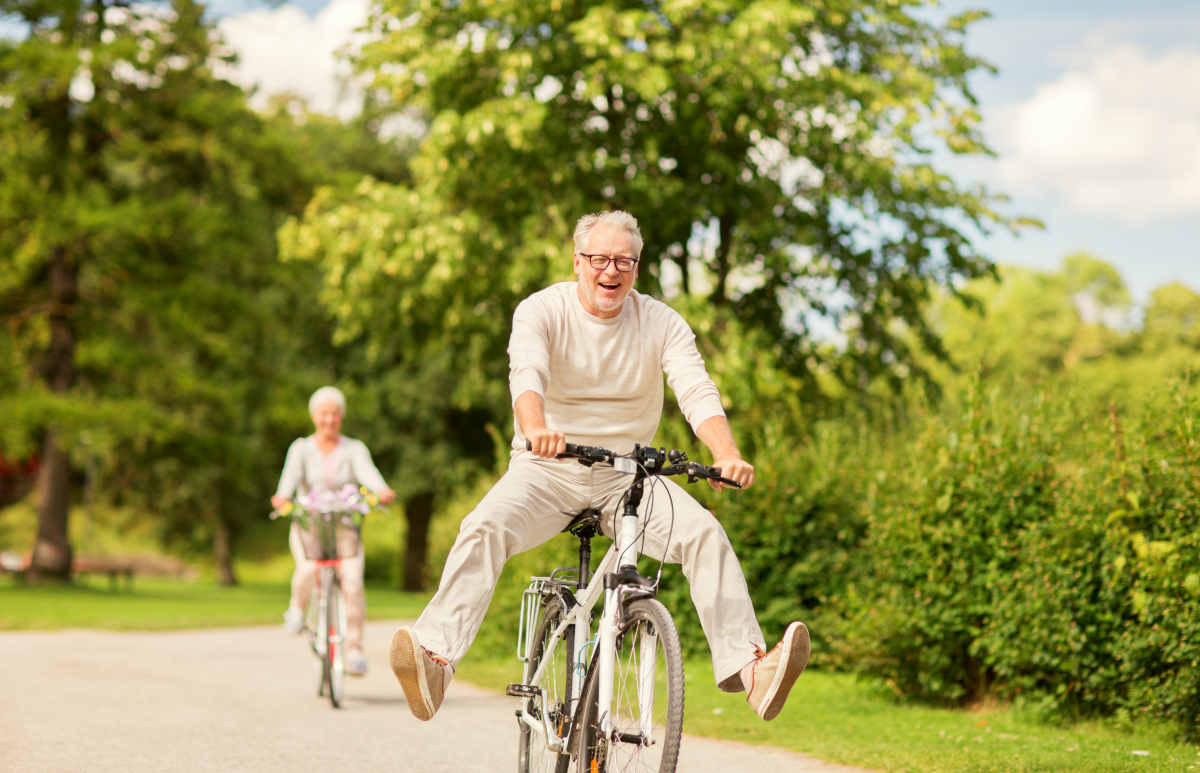 Happy senior couple riding bicycles at summer park | How to Keep The Flame Alive In Your Senior Years
