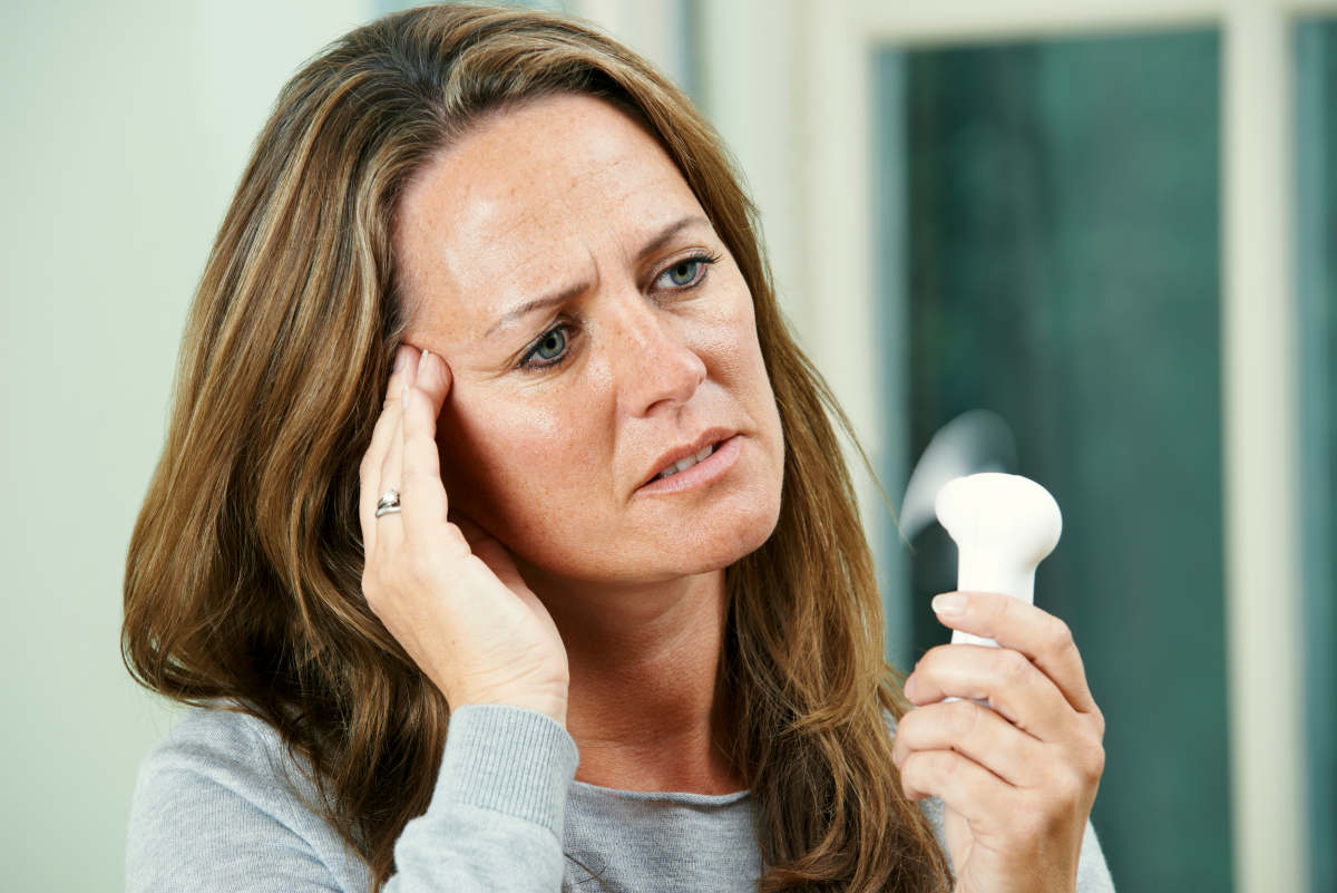 Mature Woman Experiencing Hot Flush From Menopause | Signs That You Are In Menopause