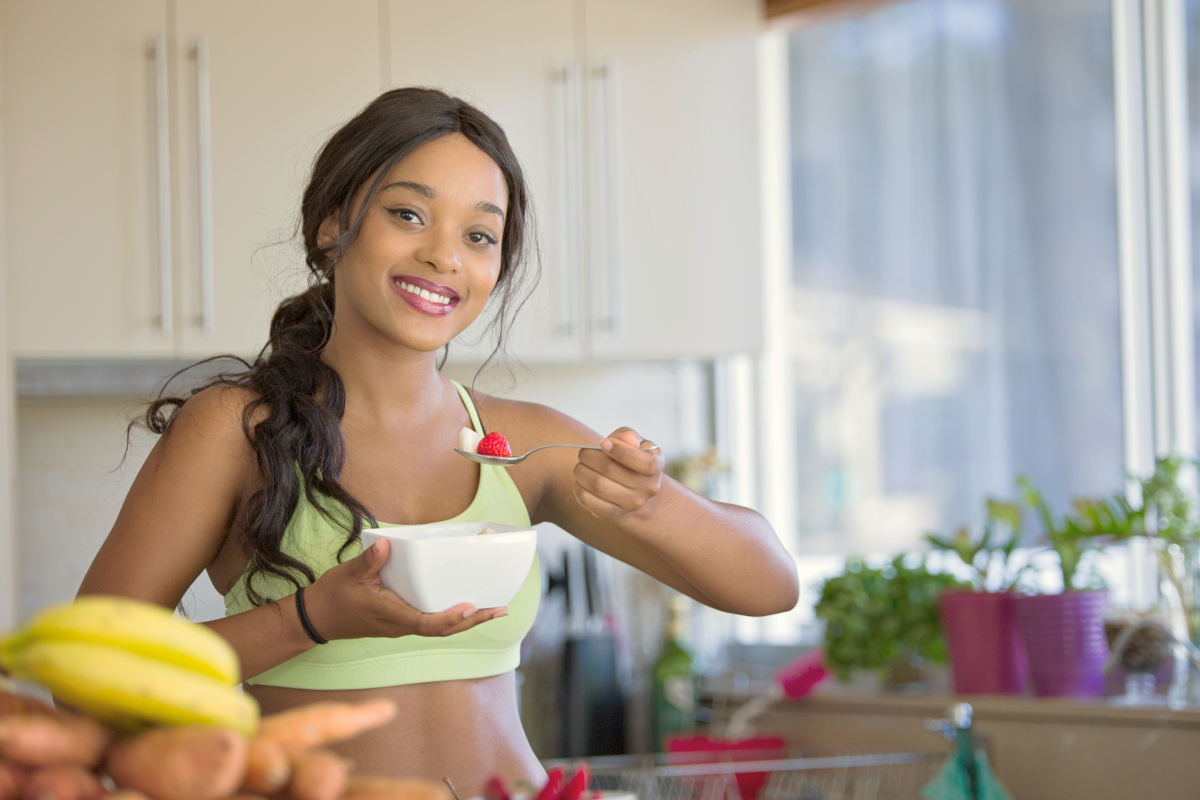 Woman eating fruit in the kitchen | Overcoming Anxiety: Anxiety Symptoms And How To Fight It | overcoming social anxiety