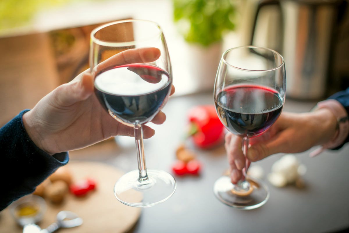 Two people toasting red wine | What Foods Make Menopause Worse? | post-menopausal women