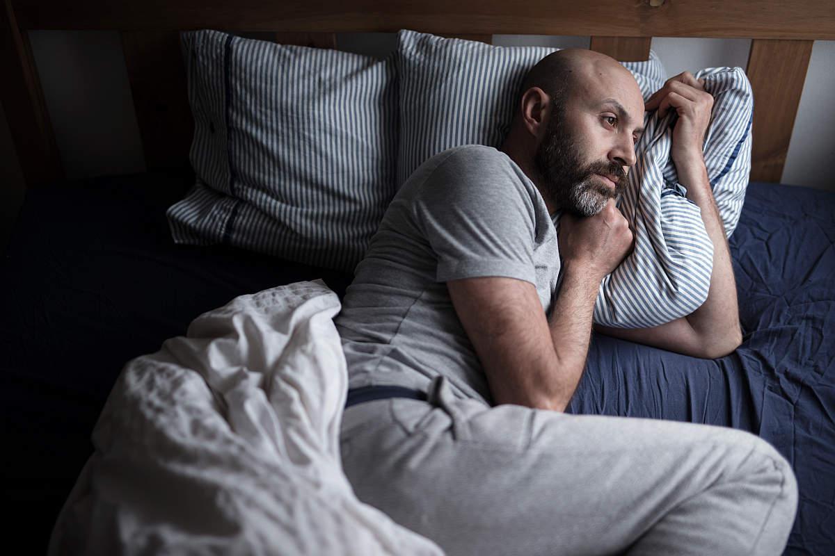 Mid forties depressed man in bed at home | Is Your Libido Low? Causes And How To Perk Back Up | Low Libido | erectile dysfunction