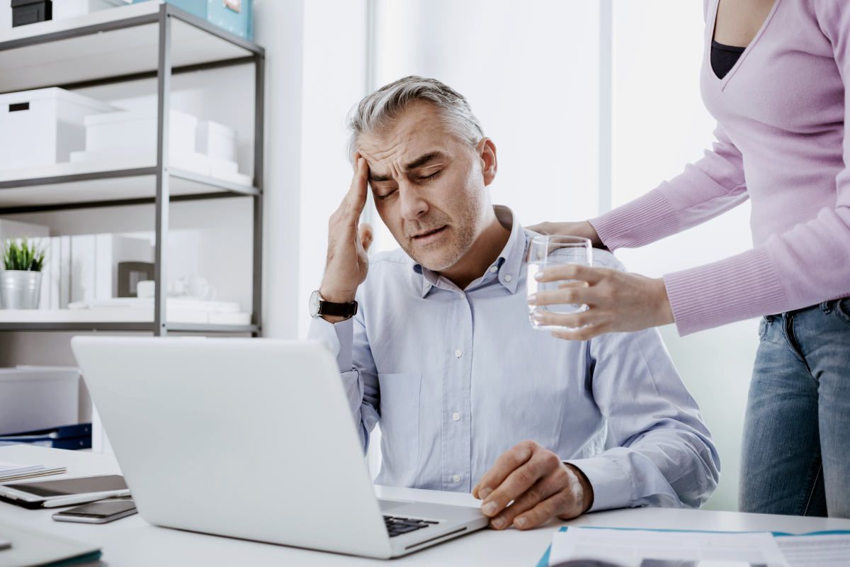 Tired businessman in the office working | What Are The Symptoms of Hormonal Imbalance? | adrenal fatigue
