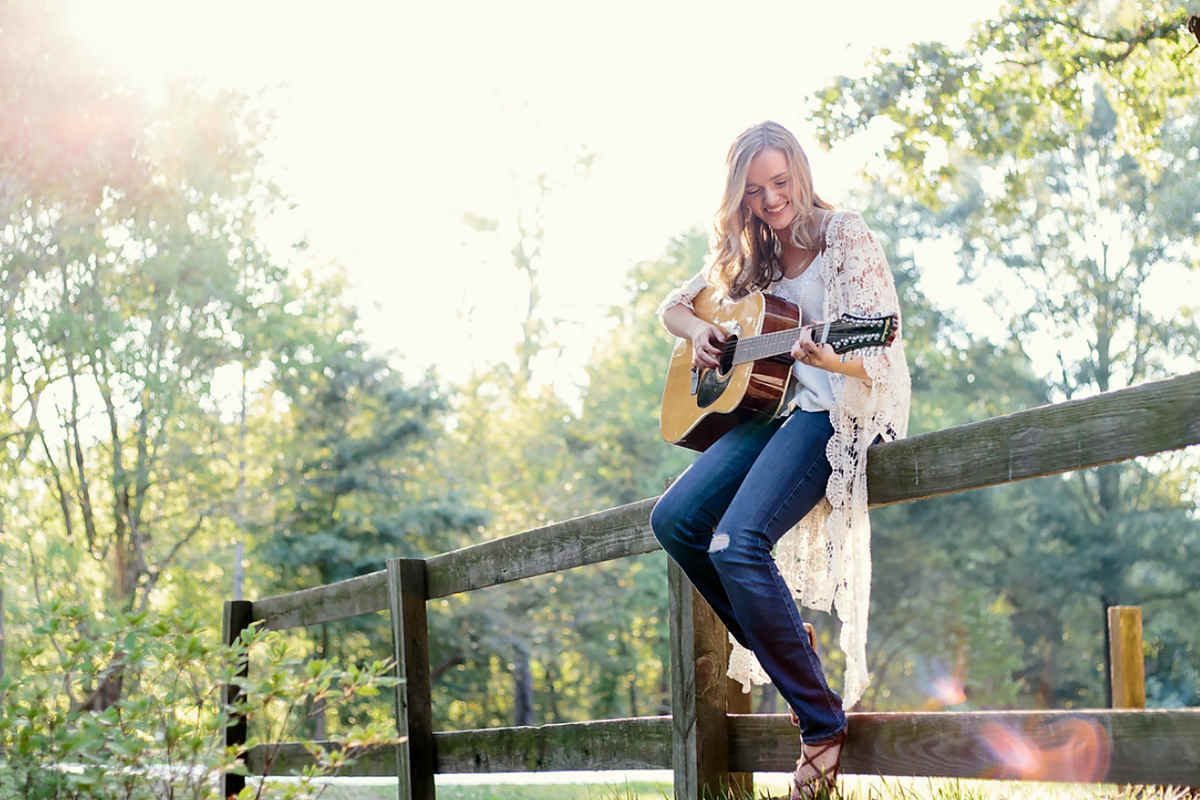 a woman playing guitar outdoors | Train Your Brain With These Mental Exercises | how to improve brain function