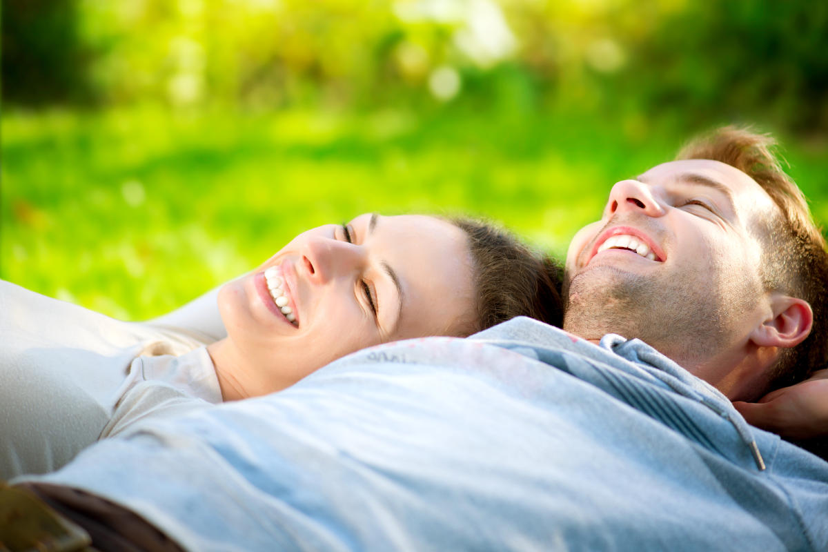 Happy Smiling Couple Relaxing on Green Grass | How To Achieve Optimal Health | optimal health wellness