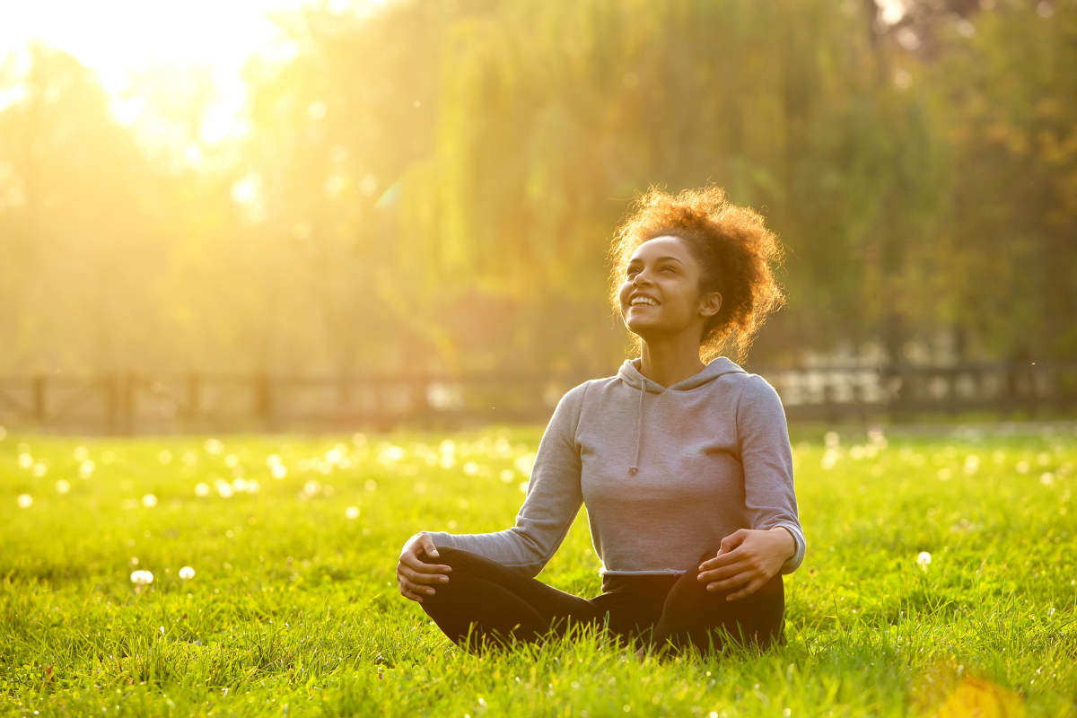 Happy young woman sitting outdoors in yoga position | Vitamin D And Thyroid | The Link Between Summer And Thyroid Health | immune cells