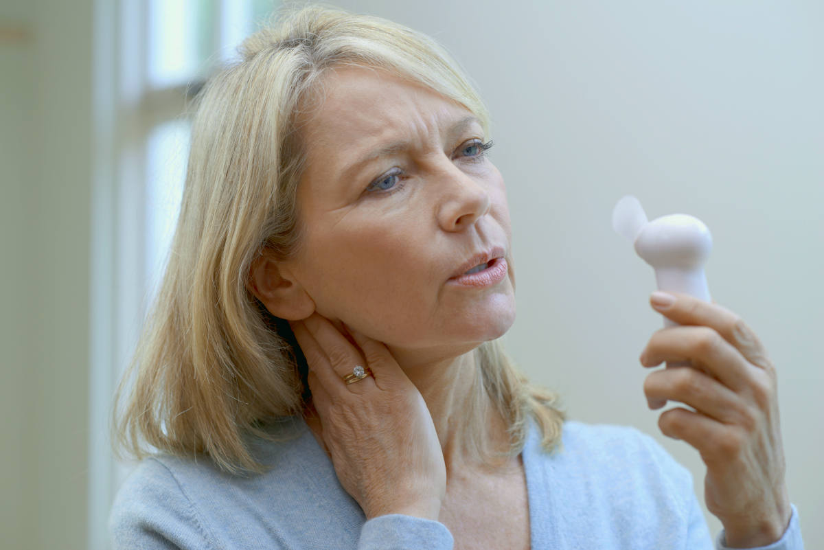 Mature Woman With Fan Experiencing Hot Flush From Menopause | All About Menopause: Signs, Stages, Age, and Treatment | menopause signs