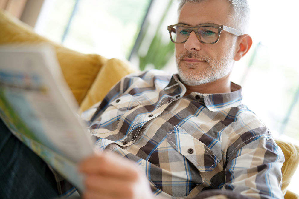 Middle-aged man in kitchen reading newspaper | Hormone Replacement Therapy For Men | Hormone Replacement Therapy Men | trt
