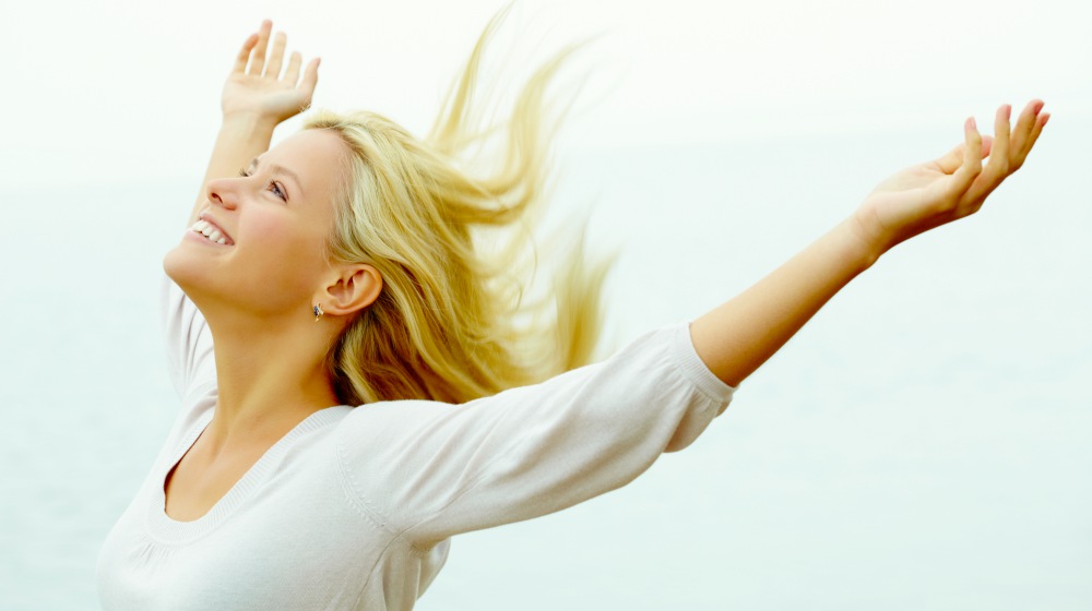 happy woman with stretched arms | Does Meditation Really Work? (Yes, Here&rsquo;s How) | does meditation work | what is mindfulness meditation