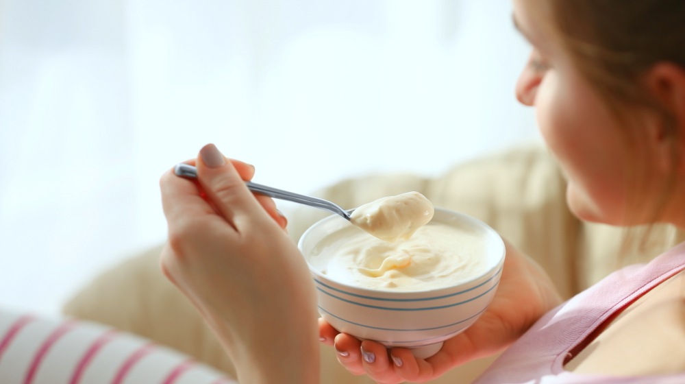woman eating a bowl of yogurt | The Connection Between High Blood Pressure And Hypothyroidism | high blood pressure and hypothyroidism | hypothyroidism