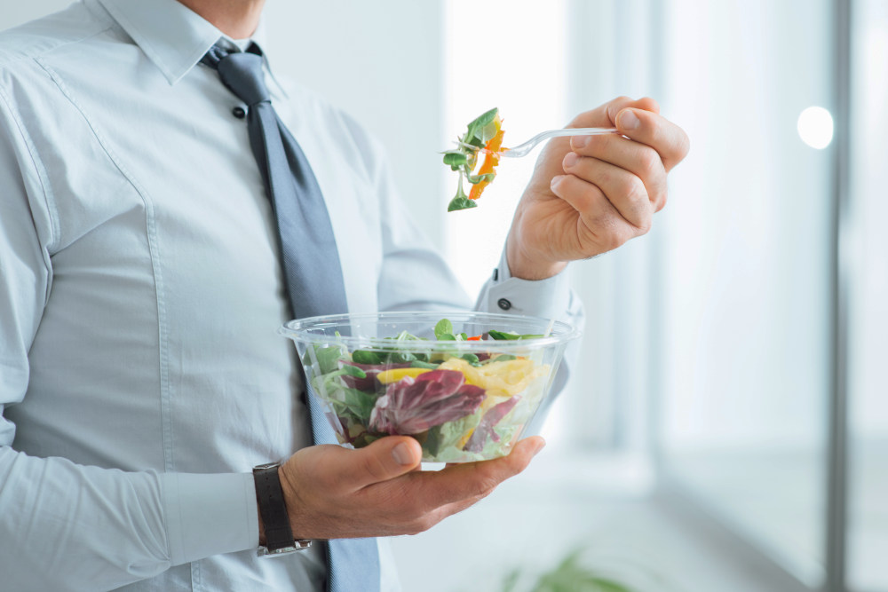 Businessman having a vegetables salad for lunch, healthy eating and lifestyle | How To Feel Better in 2020: Resolutions And Tips For Aging Well | old people food