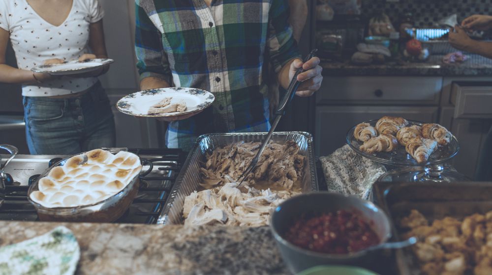 person picking food on tray | Smart and Healthy Holiday Eating Tips | healthy holiday tips | health holiday eating