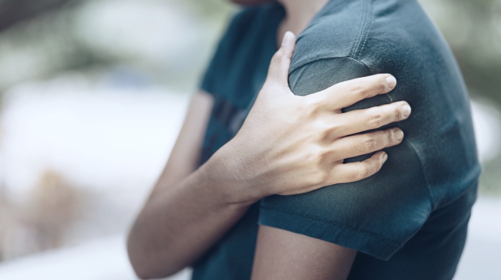 person having shoulder pain | Graves&rsquo; Disease Symptoms, Causes, And Treatment | graves' disease | graves' disease symptoms