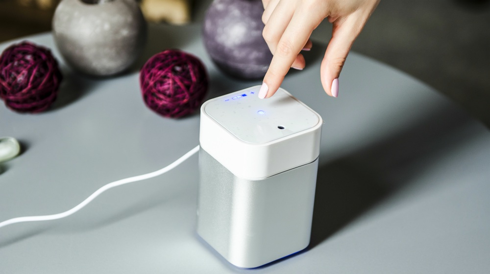 Woman turning on the air humidifier | Winter Skin Care Tips For Harsh, Cold, and Dry Weather | winter skin care | winter skin tips