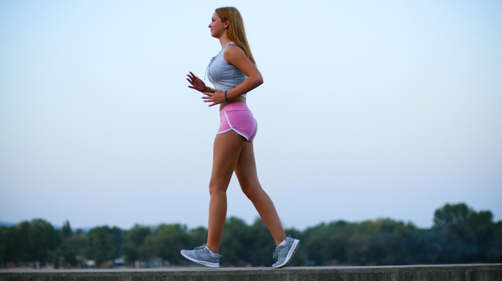 young woman briskwalking outside | How To Balance Your Hormones Naturally | how to balance your hormones | hormone balancing diet
