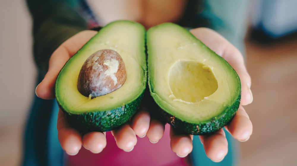 person holding avocado fruit | Power Foods To Boost Your Energy All Day | power foods | energy boosting snacks