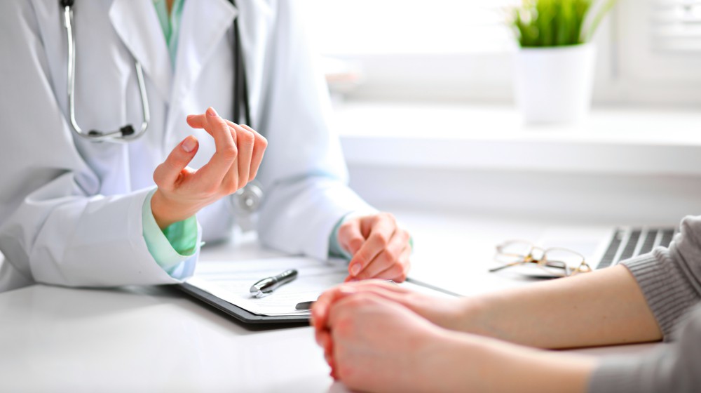 doctor and patient sitting at the desk near the window | What Is Parathyroid Hormone? | Thyroid Symptoms | parathyroid hormone | parathyroid hormone normal range