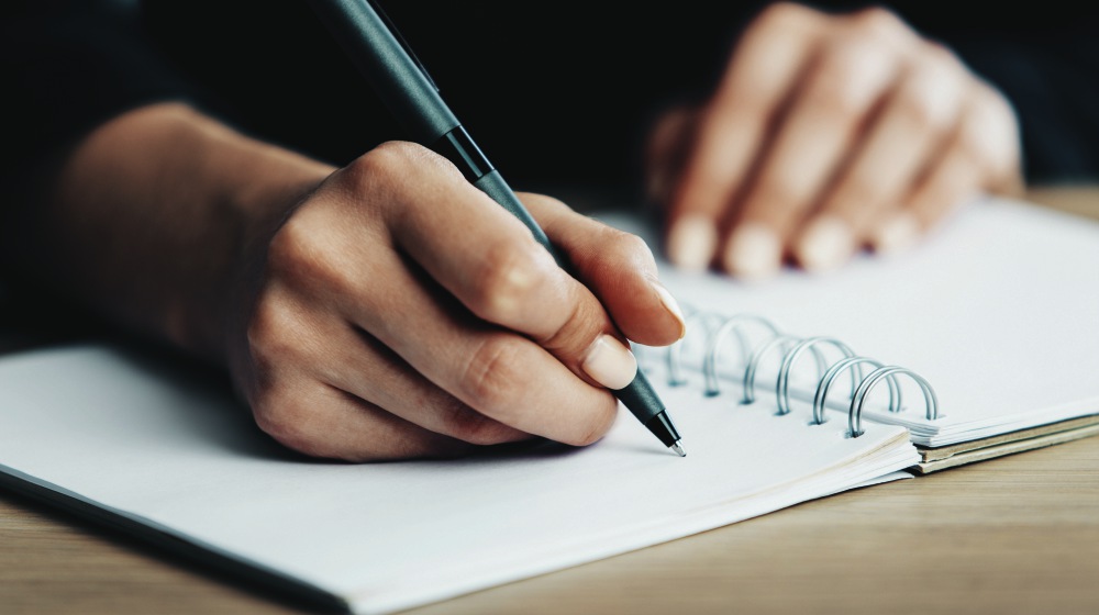 woman writing on a spiral notebook | Thyroid Neck Check: A Step-By-Step Guide For Thyroid Disorders | thyroid neck check | thyroid test