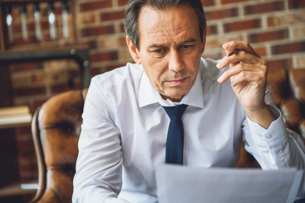 Concentrated male person looking at papers | Amazing Science-Backed Benefits Of Niacin (Vitamin B3) | nicotinic acid vitamin