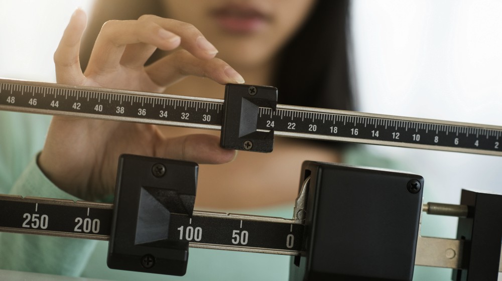 woman adjusting the weight scale | Nodule On Thyroid Gland? What To Do Next | nodule on thyroid | thyroid nodules causes