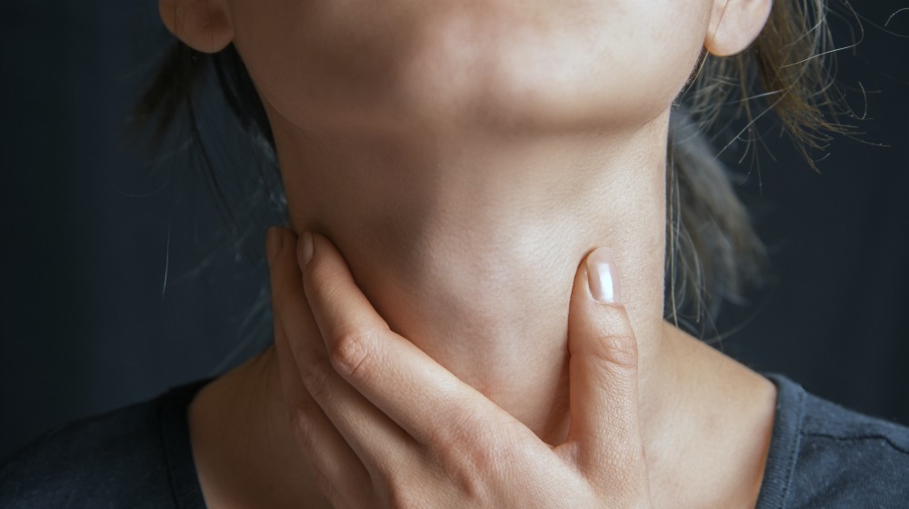 woman holding her neck | Thyroid Storm Facts Thyroid-Patients Need To Know | thyroid storm | thyroid storm diagnosis