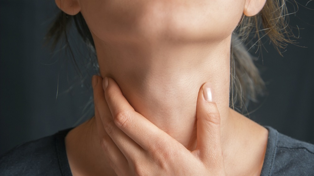 woman holding her throat | Thyroid Neck Check: A Step-By-Step Guide For Thyroid Disorders | thyroid neck check | thyroid test