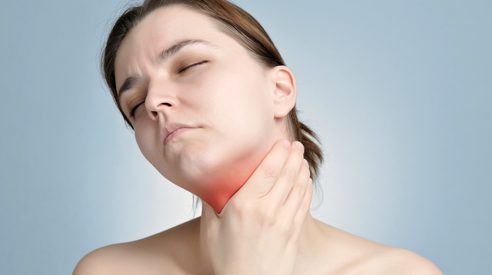 young woman holding her painful neck | What Is Parathyroid Hormone? | Thyroid Symptoms | parathyroid hormone | parathyroid hormone level