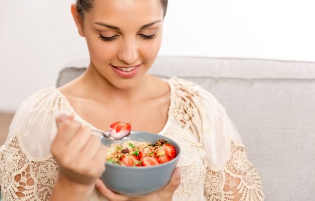 a young woman holding a bowl of strawberry and cereal | Eat Well for Better Energy | 5 Tips To Have More Energy and Better Mood At Any Age